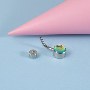 Macro shot of silver stainless steel belly ring with rainbow stone and threaded disc