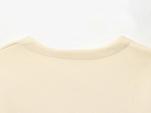 Close-up detail of beige ribbed knit texture and round neckline on a stylish women's set
