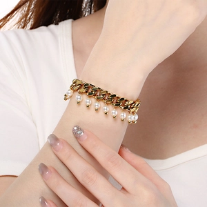 Detailed shot of golden 9mm Cuban chain bracelet with glossy white pearl charms