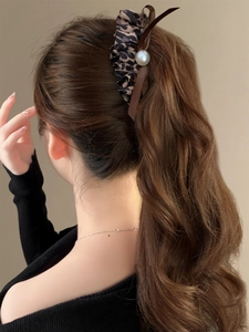 Brown leopard print bow hair scrunchie with pearl detail on a woman's ponytail