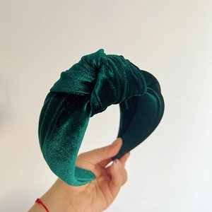 Detailed view of the dark green velvet texture and knot design on the wide headband