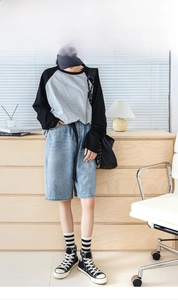 Close-up of black and white striped socks paired with high-top sneakers and denim shorts
