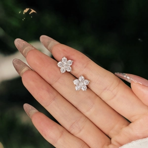 Gros plan sur les boucles d'oreilles fleur de prunier en argent S925 et oxydes de zirconium
