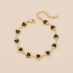 Detail of adjustable gold-plated stainless steel bracelet with green heart gemstones