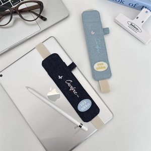 Detail of denim elastic pen sleeves with butterfly embroidery on tablet cover