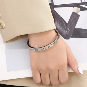 Detail showing hollow star cutouts on a polished silver stainless steel cuff bracelet