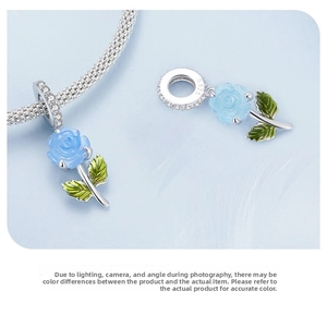 Detailed macro view of S925 silver blue rose flower charms with crystals and green enamel