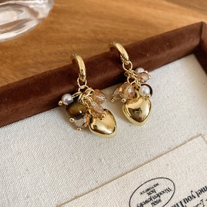 Macro shot of tiger eye heart tassel earrings with gold hoop and vintage beads detail