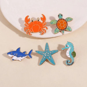 Set of 5 enamel pins featuring colorful crab, turtle, shark, starfish and seahorse motifs