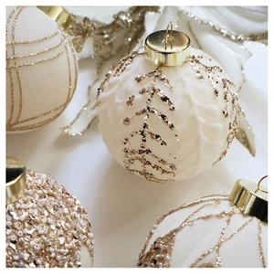 Detail of white velvet Christmas ornaments with gold glitter and bead patterns