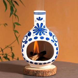 Blue and white ceramic Palo Santo holder with floral patterns on a wooden base