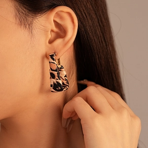 Macro shot of retro leopard print hoop earrings made of faux leather and silver needles