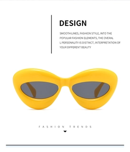 Detail of bright yellow thick frame cat eye sunglasses with dark UV lenses on white