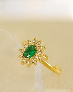 Macro detail of sunflower ring with green oval gemstone and small white crystals