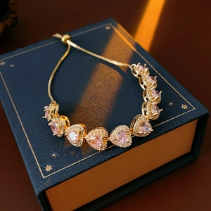 Detail of pink heart-shaped stones and adjustable gold slider chain on the bracelet