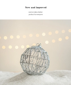 Close-up of a silver hollow geometric Christmas ball ornament on artificial snow
