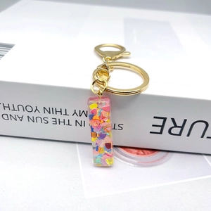 Detail of letter I keychain with colorful heart sequins in transparent resin material