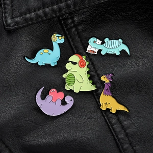 Detail view of five colorful enamel dinosaur brooches displayed on black leather