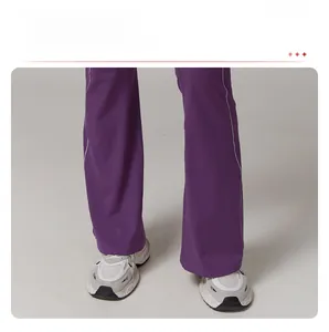 Détail du pantalon de yoga évasé violet foncé avec tissu de sport élastique et doux