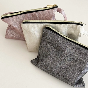 Detailed macro view of sequin texture on cosmetic bags in pink, silver and grey colors