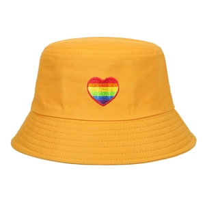 A stylish yellow bucket hat featuring detailed rainbow heart embroidery on front