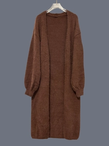 Dettaglio di un cardigan lungo in finta pelliccia con morbida texture pelosa marrone