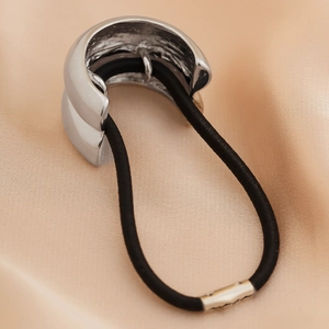 Close-up of polished silver metal hair cuff with inner anti-slip texture and black elastic