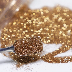 Champagne gold nail glitter powder in a metal spoon with 0.2mm fine shimmer texture