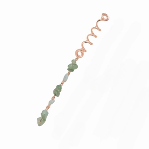 Detailed close-up of rose gold spiral hair jewelry with natural green stone pendant charm