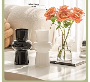 Three-tier geometric glass vases in black, frosted white, and clear with pink roses