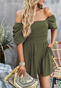Detail of green off-shoulder romper with puff sleeves and cinched waist design