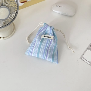 Detailed close-up of striped drawstring pouch with Sozakka label on a white desk