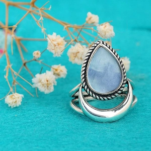 Macro shot of retro drop-shaped blue stone ring with crescent moon base and twisted silver edge
