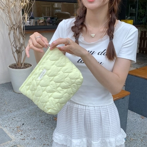 Close-up of quilted heart pattern and soft fabric texture on this stylish makeup bag