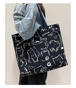 Detail of black canvas tote bag with white cat illustration and Mi Mi text print