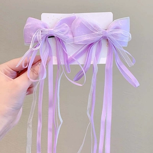 Detail of purple tulle bow hair clips with long satin streamers on a display card