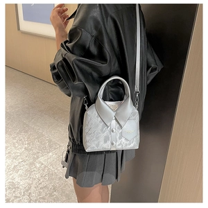 Close-up of silver shirt-shaped handbag featuring unique collar and button details