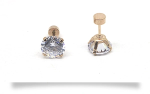 Détail macro de boucles d'oreilles en acier rose doré avec zircons cubiques clairs