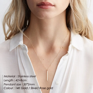 Minimalist stainless steel bar pendant necklace on a model wearing a white shirt