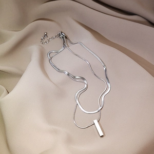Detail view of silver double-layer layered necklace with snake chain and bar pendant