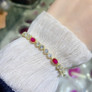Detailed shot of red ruby and white zircon gold-plated bracelet on a female wrist