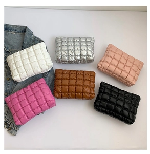 Vue à plat de pochettes matelassées bouffantes en blanc, argent, rose et noir