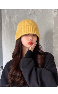 Close-up of thick ginger yellow knit texture on a warm winter beanie hat for women