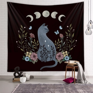 Bohemian black tapestry with moon phases and mystic cat silhouette on a white brick wall