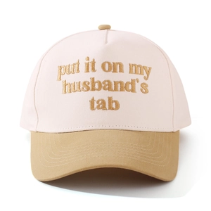 Detail of cotton baseball cap featuring contrast brim and gold embroidered letter text