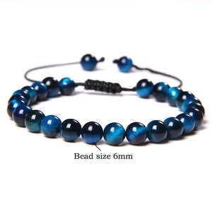 Detail shot of 6mm blue tiger eye stone beads on an adjustable woven bracelet cord