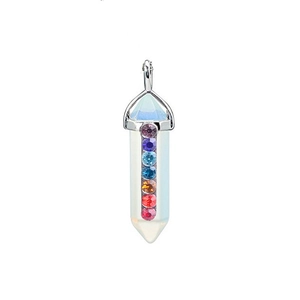 Macro shot of a hexagonal white crystal pendant with colorful chakra gemstones in a metal setting