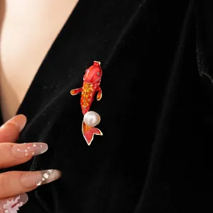 Exquisite koi fish brooch with red enamel and white pearl on black velvet background