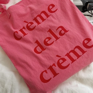Nahaufnahme der Textur einer rosa Canvas-Tasche mit rotem crème de la crème Aufdruck