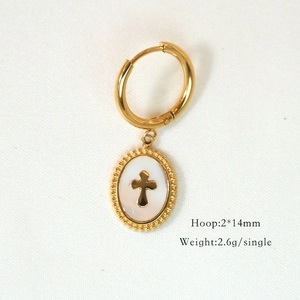 Detailed view of a gold cross pendant earring with polished finish on white background